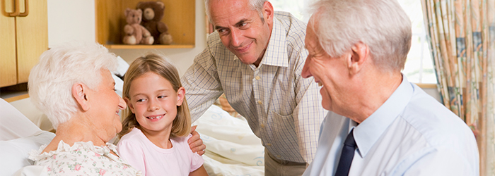 Family spending time with hospice patient smiling