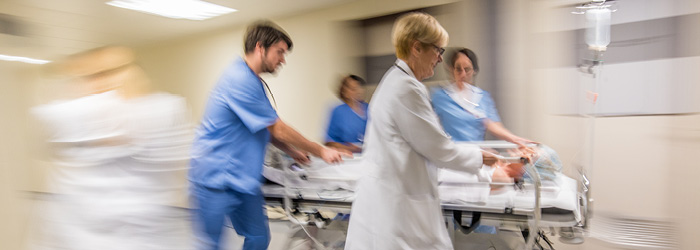 Hospital employees attending to patient in stretcher